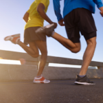 Three individuals jogging across a bridge