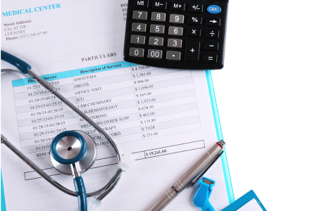 A calculator and medical bills on a table