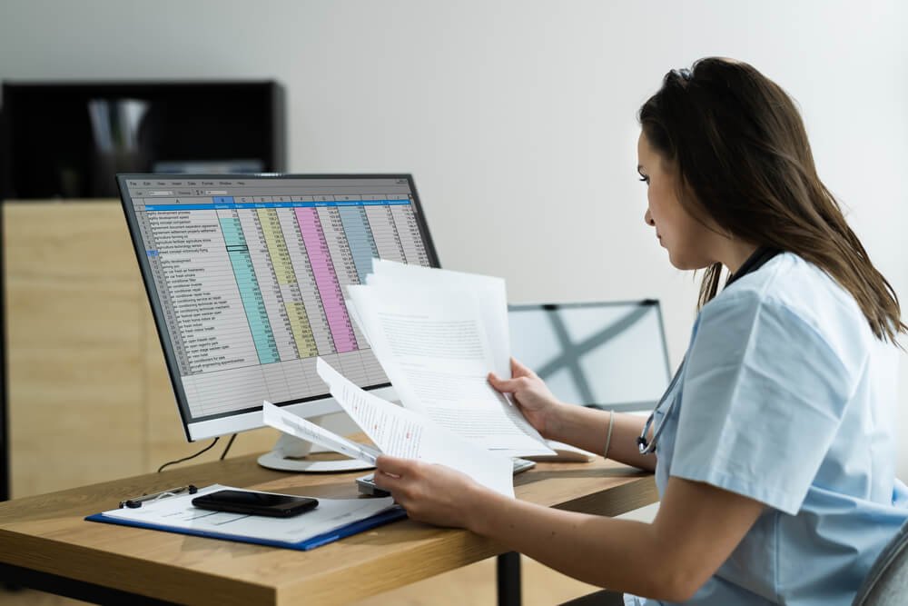 Woman in blue shirt at desk with computer screen