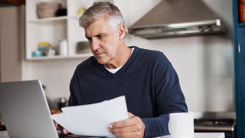 A man reviewing a document on his laptop screen
