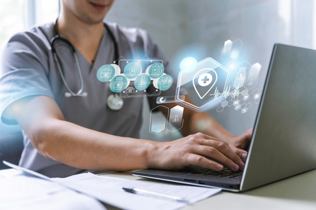 Healthcare professional using a laptop with futuristic medical infographics interface overlay.